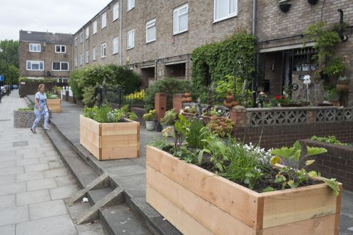 Planter boxes lining a street in front of terrace housing in Hackney, London