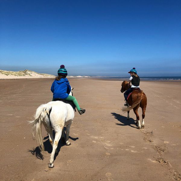 Children riding on Druridge Bay beach