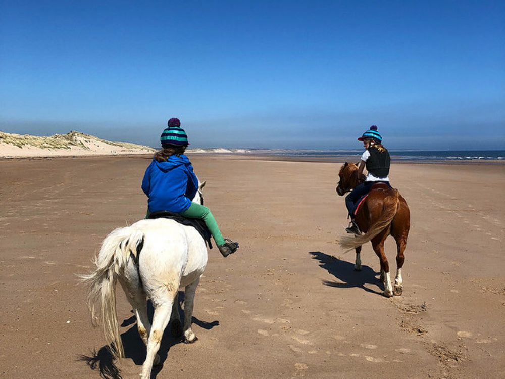 Children riding on Druridge Bay beach