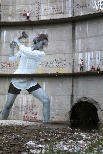 A very large illustration on rock of a woman swinging her mallet