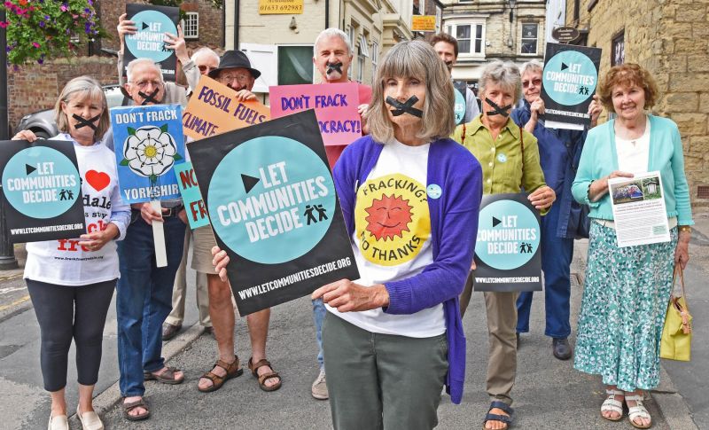 Frack Free Malton and Norton protesters against permitted development in street with banners and mouths taped.