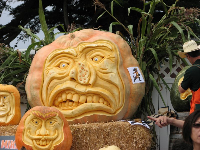 3 pumpkins with artistic carved faces on show at the Half Moon Bay Pumpkin Festival 2011