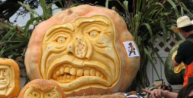 3 pumpkins with artistic carved faces on show at the Half Moon Bay Pumpkin Festival 2011