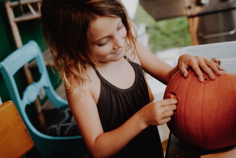 Young girl carving pumpkin