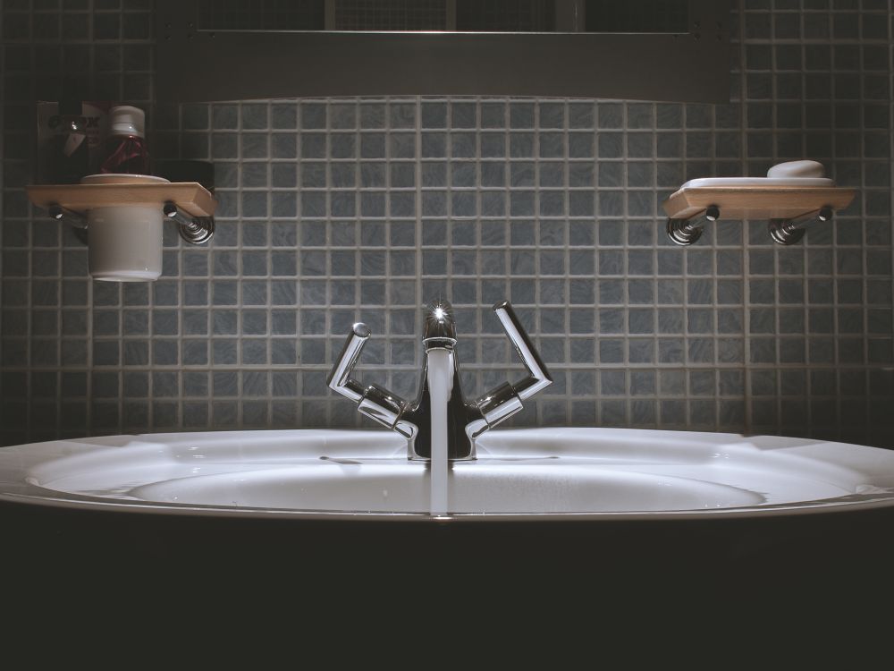 bathroom sink against dark grey tiled walls