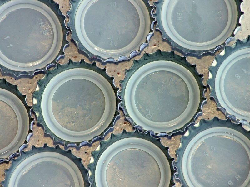 Metal bottle caps containing a plastic seal