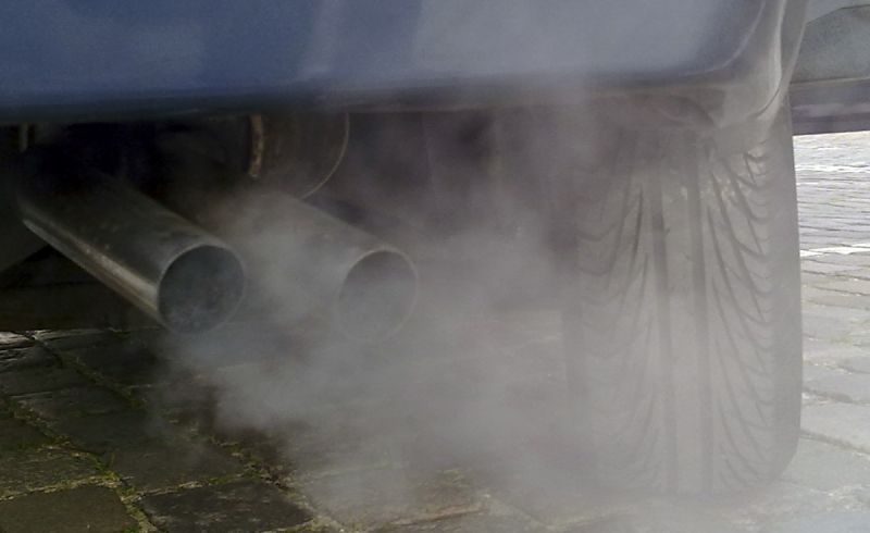Car exhaust pipe emitting cloud of fumes