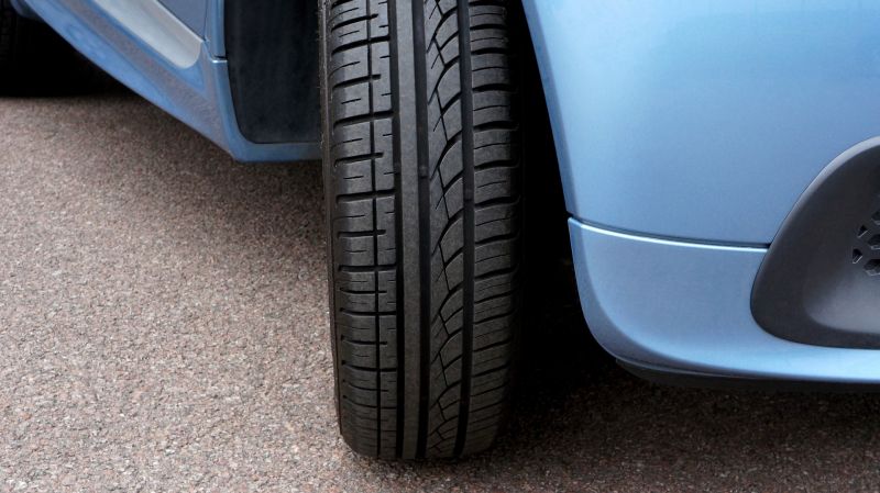 Close up of the front right tyre of a nondescript blue car