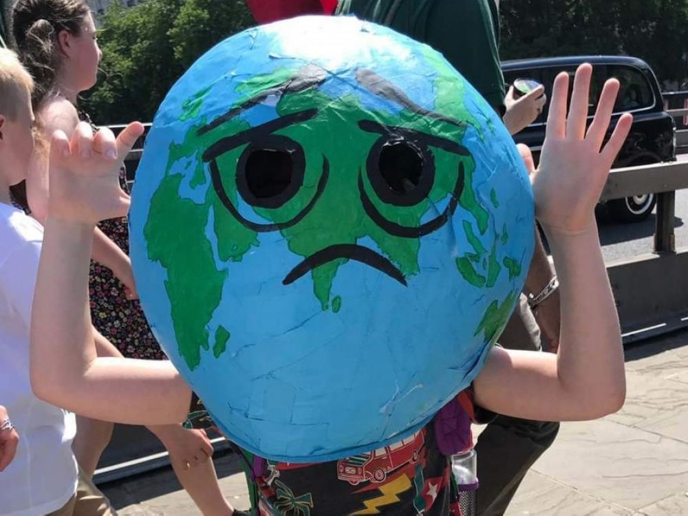 Child wearing Earth head prop