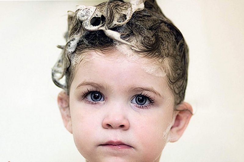 Child with soap suds on hair