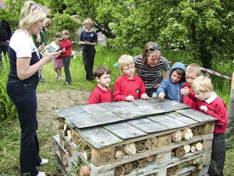 Children making a large bee hotel