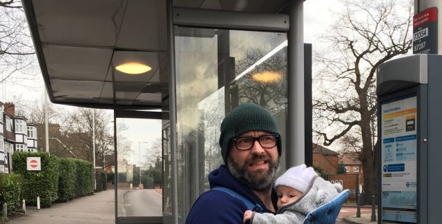 author with baby at bus-stop