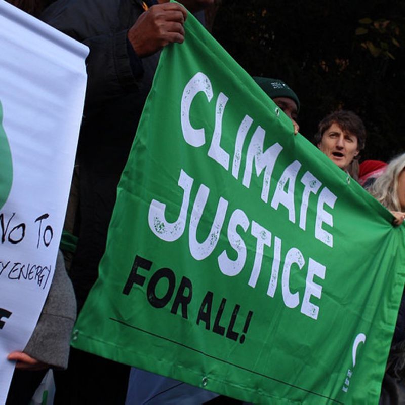 Friends of the Earth protesters holding a Climate Justice For All banner