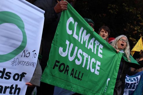 Friends of the Earth protesters holding a Climate Justice For All banner