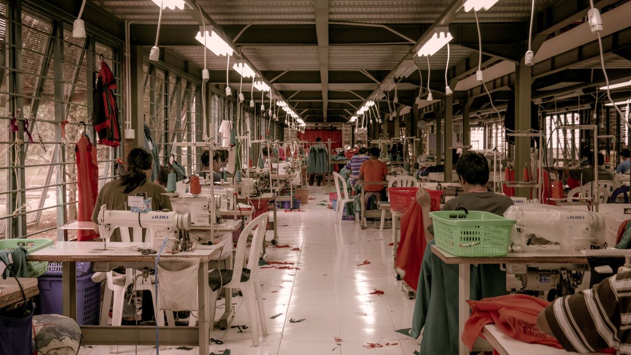 A number of workers sat at sewing machines in a clothing factory
