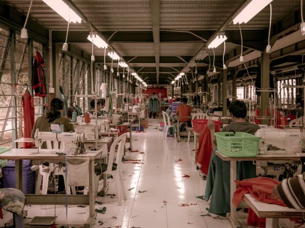 A number of workers sat at sewing machines in a clothing factory