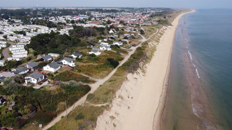 An aerial shot of homes very close to the coastline