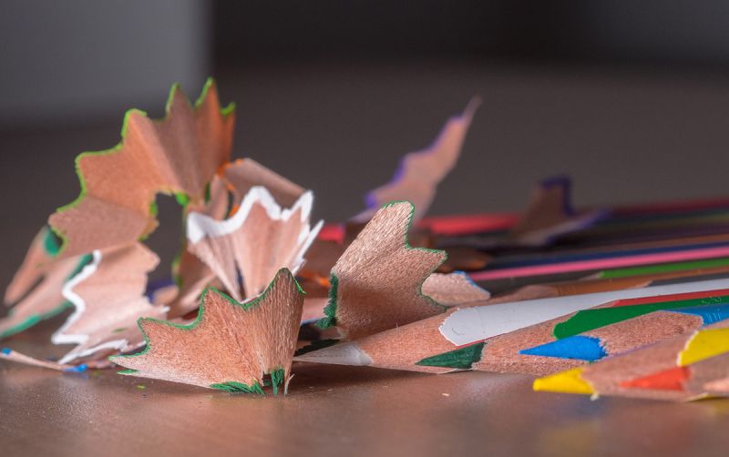 Multi-coloured wooden pencils with shavings on desk