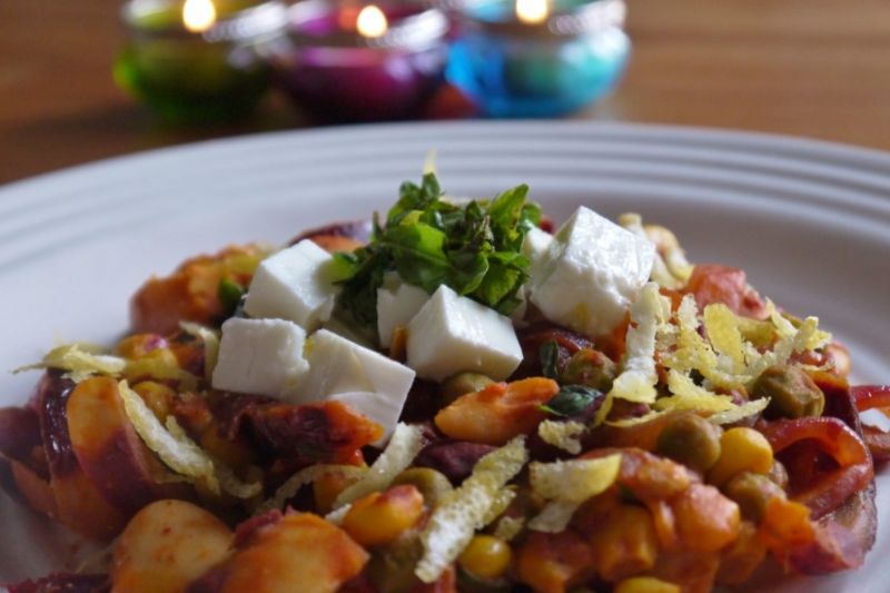 Harissa, kidney bean and chickpea one-pot dinner with feta and fresh herbs on a plate