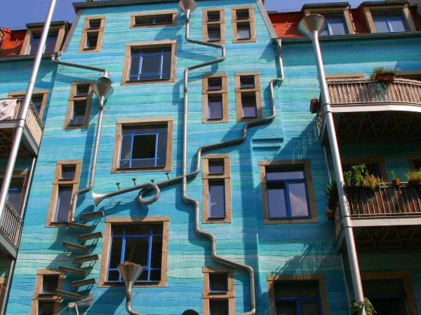 Blue house with arty, surreal water collection system of funnels and pipes running down the side