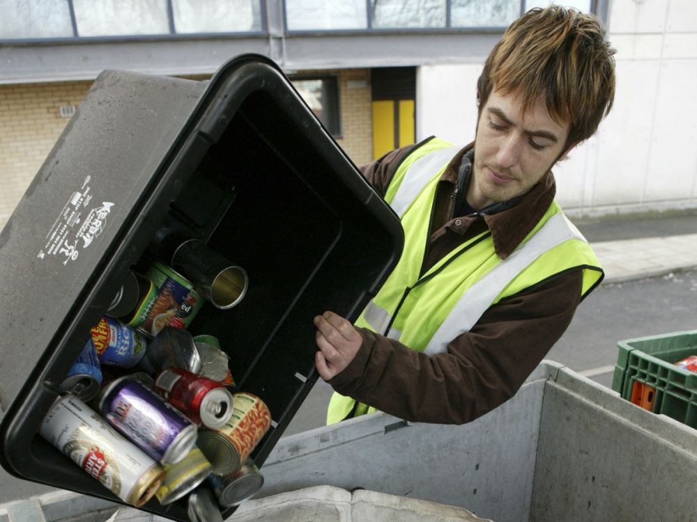 Man in hi-vis emptying a box of household recycling into a recycling van