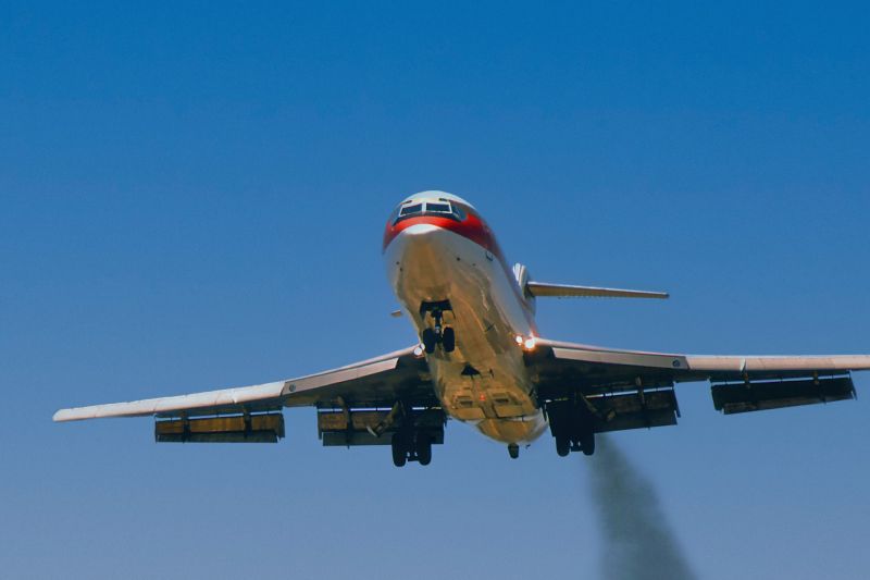 Dirty airplane in beautiful blue sky, emitting black smoke