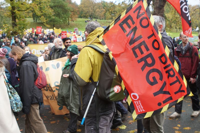 Protesters with one holding a large flag which reads 'No to dirty energy'