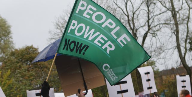 A protest flag close-up that says 'people power now'