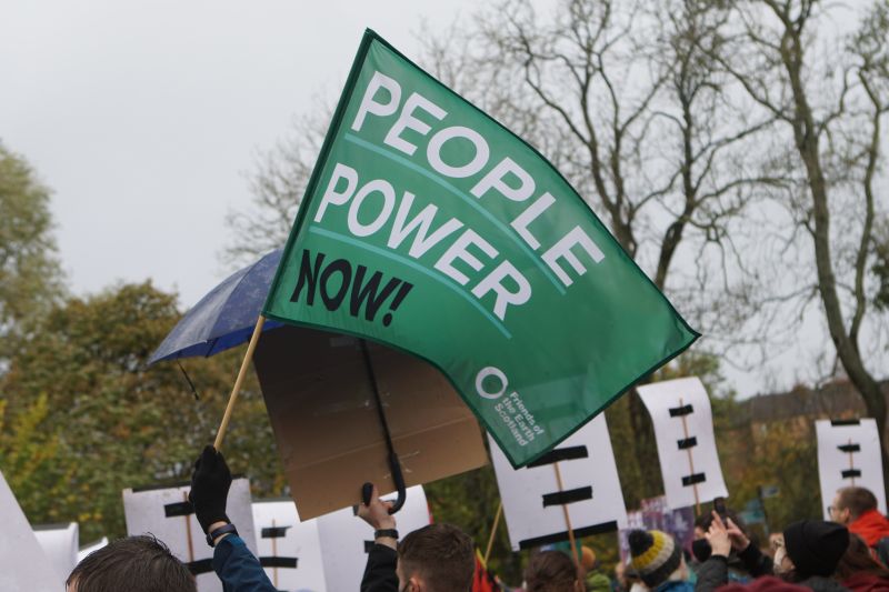 A protest flag close-up that says 'people power now'