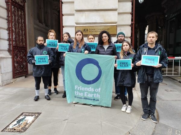 Group of people holding "Free Alaa" signs and a Friends of the Earth banner