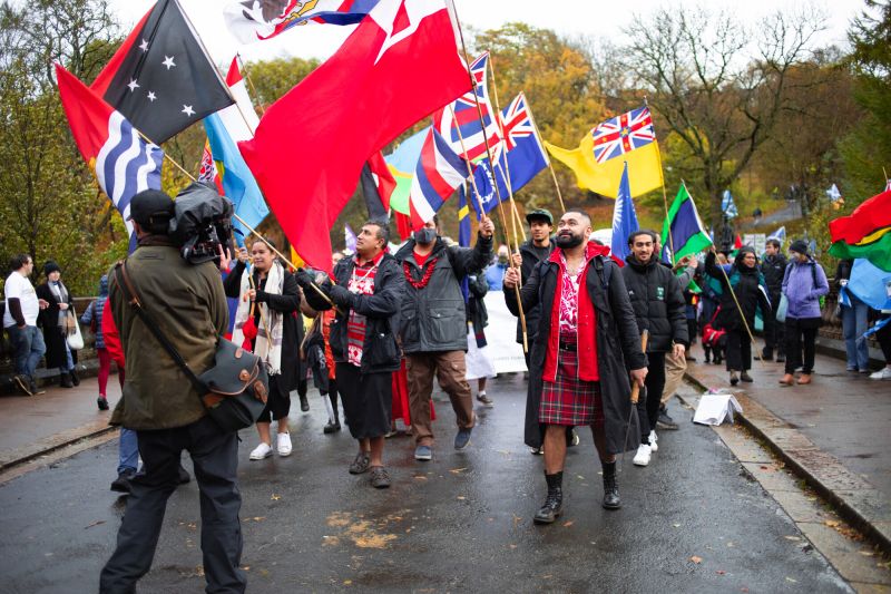 Group of international activists at a COP26 march, waving their countries' flags
