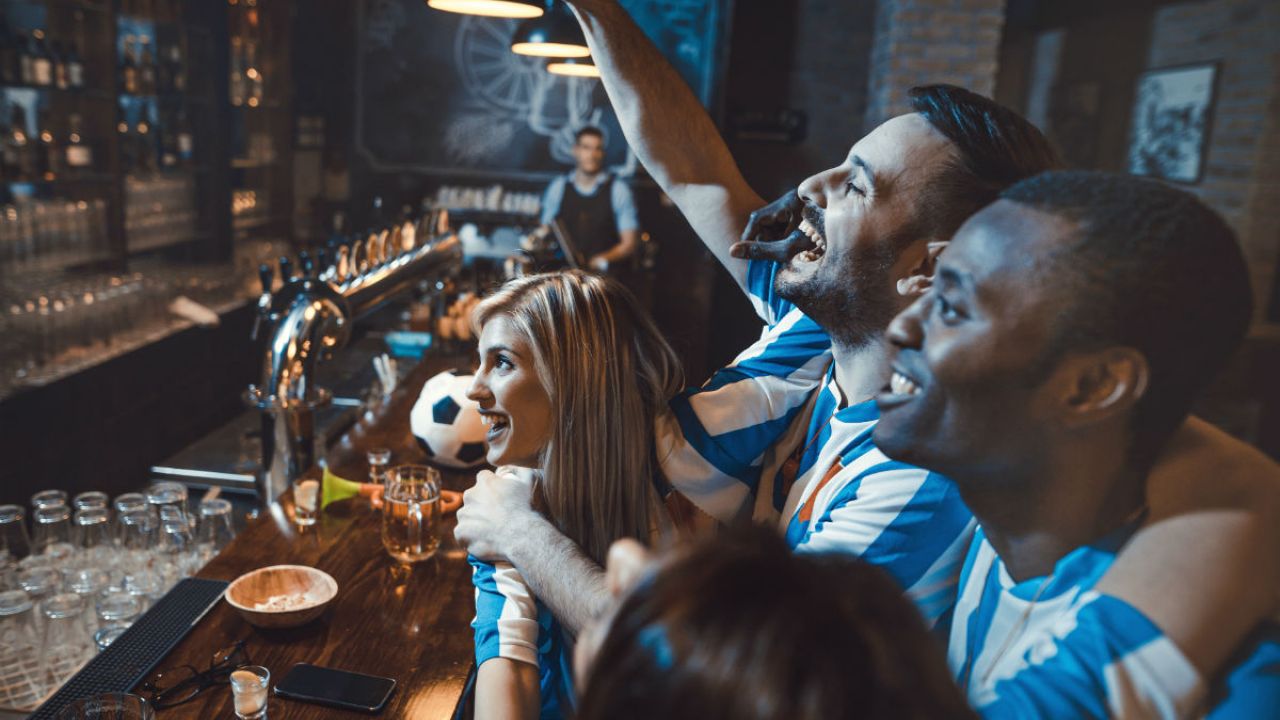 football fans cheering their team on in a bar
