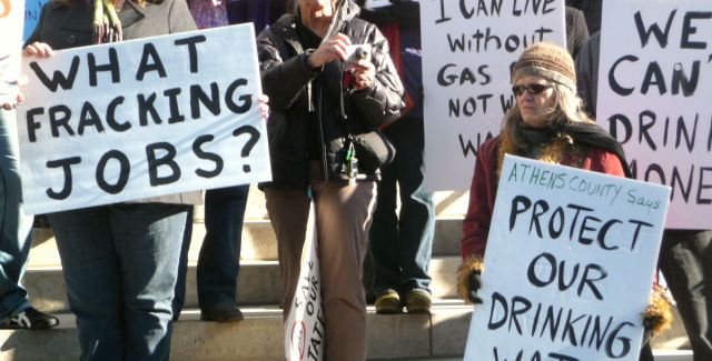 People hold up banners at a fracking protest in Ohio, US