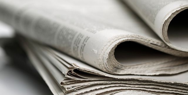 Shallow depth-of-field photo of a stack of newspapers