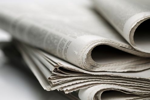 Shallow depth-of-field photo of a stack of newspapers