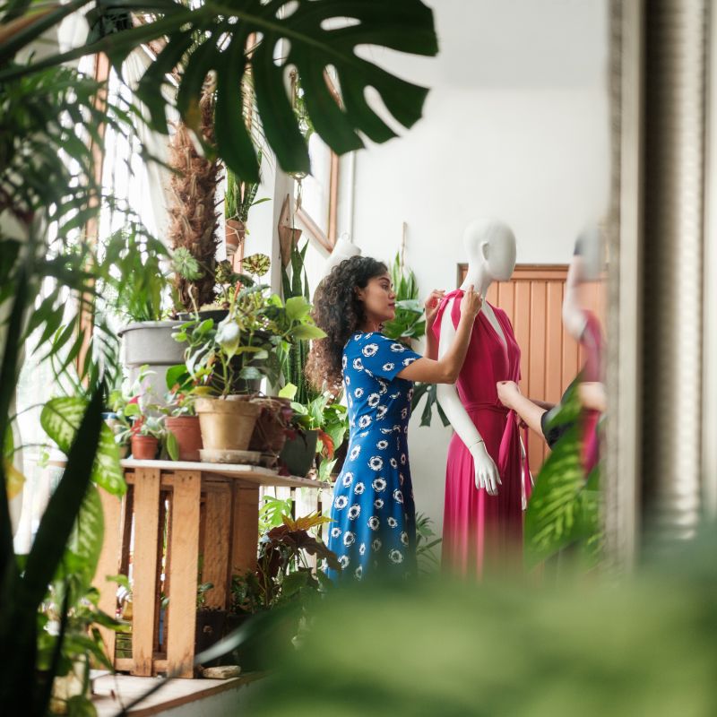 Young woman dresses a mannequin in an eco clothing store