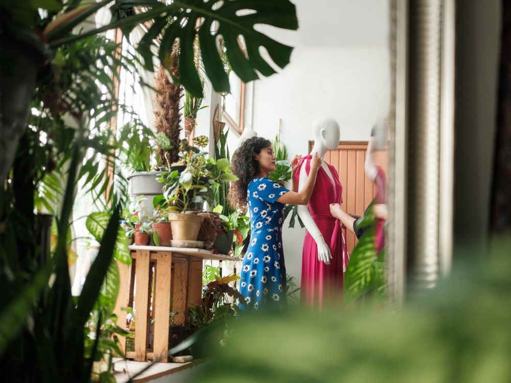 Young woman dresses a mannequin in an eco clothing store