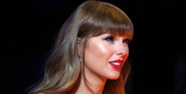 A side profile headshot of Taylor Swift wearing red lipstick