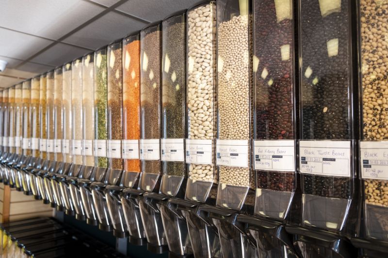 A food refill station with stocks of beans, oats, lentils and dried produce.