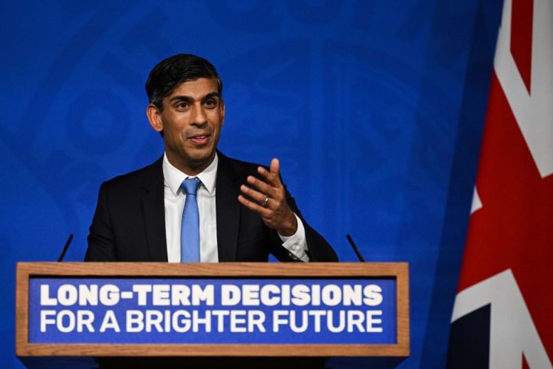 Prime Minister Rishi Sunak stands at a lectern with the slogan "Long-term decisions for a brighter future" while giving a press conference on delaying green policiesvers a press conference