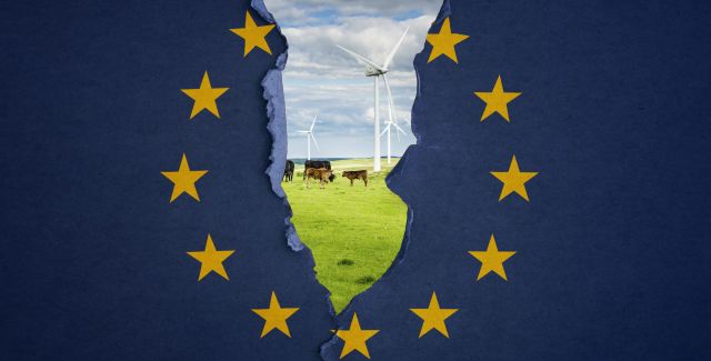 The EU flag ripping down the middle to reveal a field with wind turbines and cows