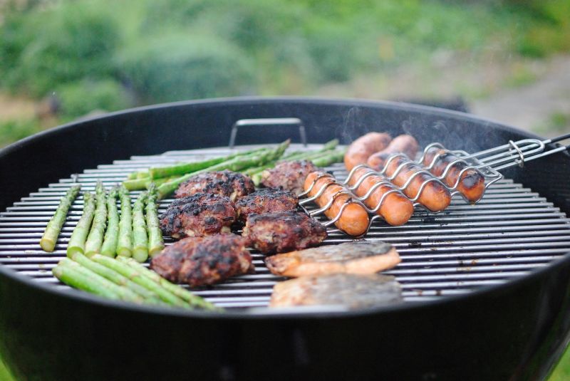 Barbecue grill with burgers, sausages and asparagus