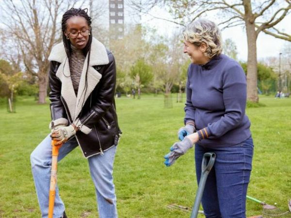 Two women digging and chatting