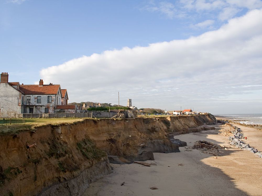 Signs of coastal erosion in Happisburgh, Norfolk: people's back gardens disappearing into the sea