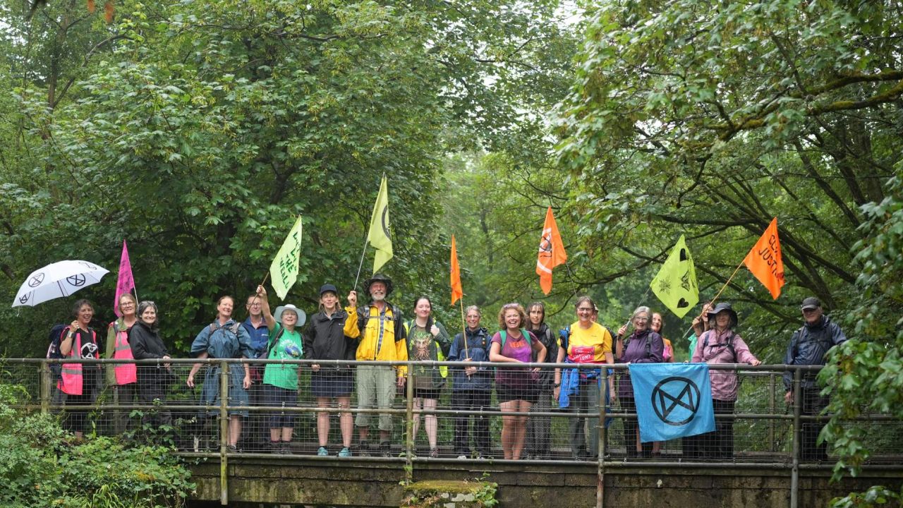 A group of people with banners standing on a bridge