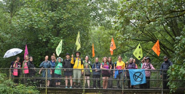 A group of people with banners standing on a bridge