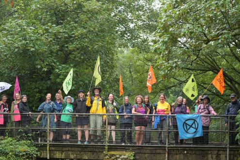 A group of people with banners standing on a bridge