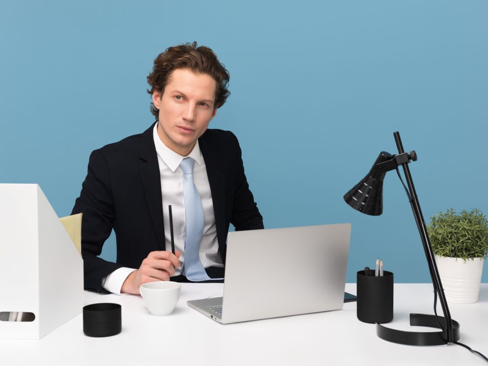 Man wearing suit at desk with computer