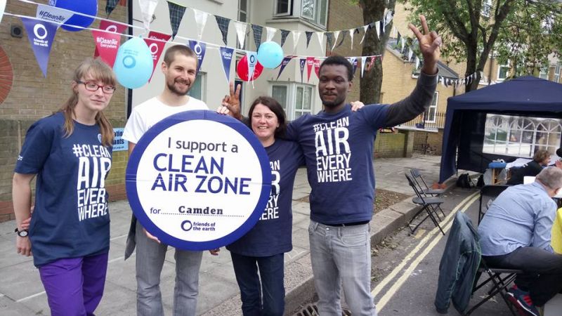 Camden Friends of the Earth. Clean Air Week of Action stall in street with people holding Clean Air Zone sign.