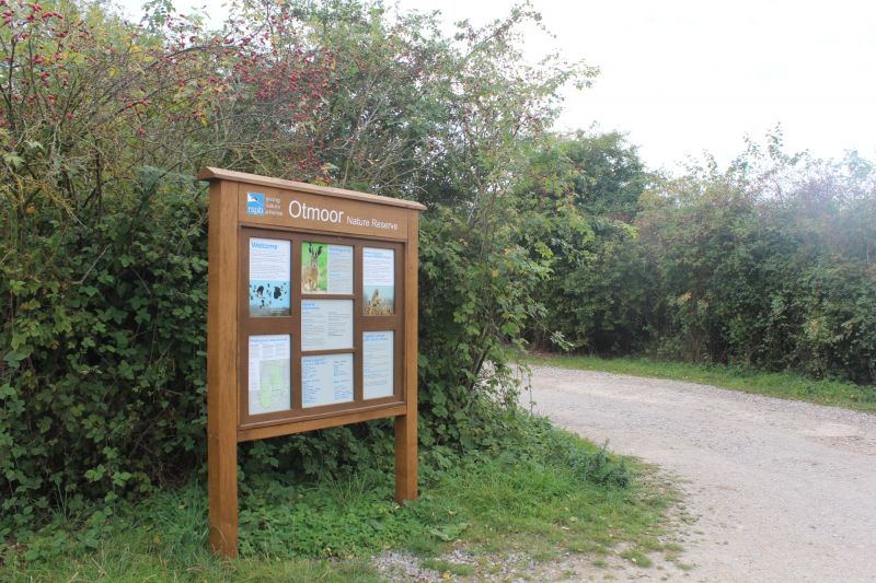 Wooden RSPB sign at leafy entrance to Otmoor Nature Reserve.